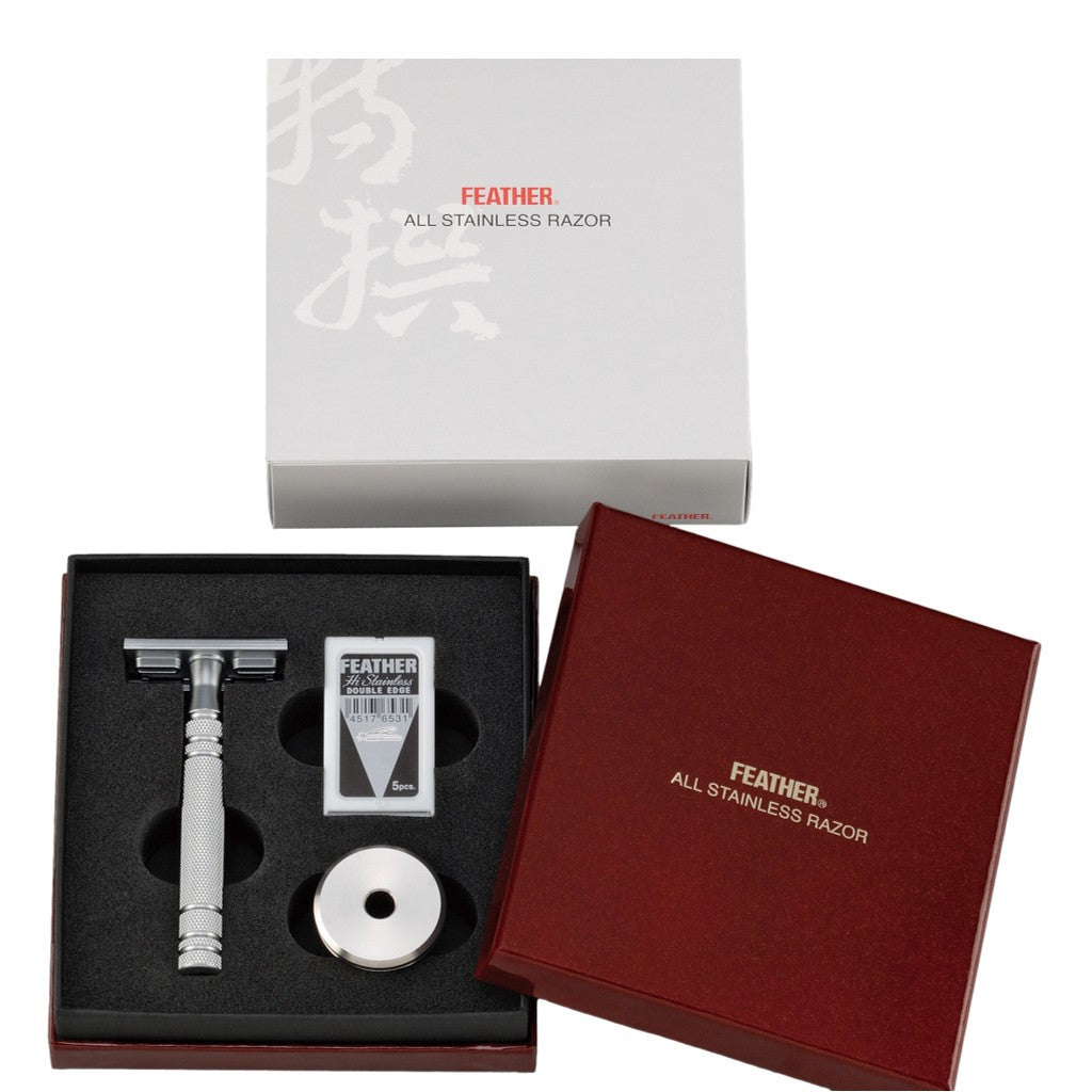 Feather All Stainless Safety Razor set inside its elegant presentation box with a razor, blades, and stand included.