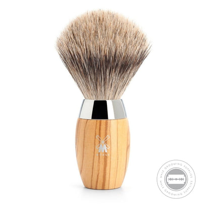 The MÜHLE Kosmo Fine Badger Shaving Brush with a sleek olive wood handle and chrome-plated accents, designed for a comfortable grip and precise shaving experience.